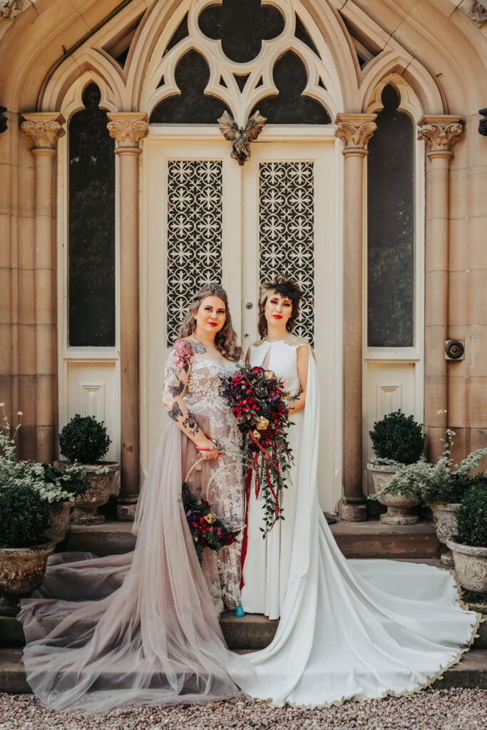 Two brides stand outside the entrance to Dunwood Hall Estate, Stoke on Trent for a Dungeons and Dragons Styled wedding shoot