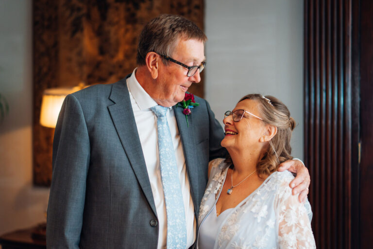 An older bride and groom look lovingly at each other after their ceremony at Hemswell Court