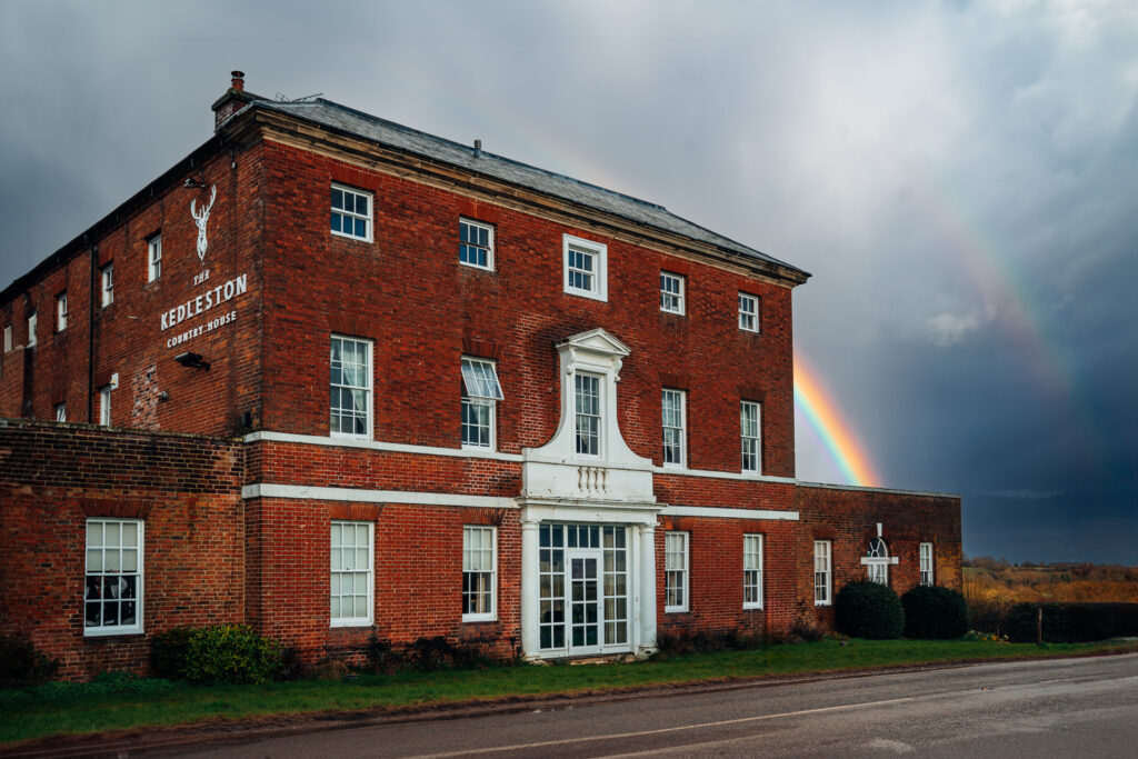 The exterior of Kedleston Country House, Derbyshire with a rainbow and stormy sky