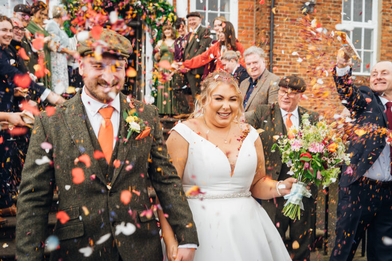 Bride and groom in shower of confetti at Kedleston Country House