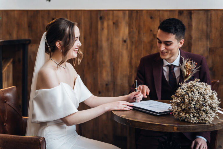 Bride and groom sign the register after their ceremony at The River Mill Derby