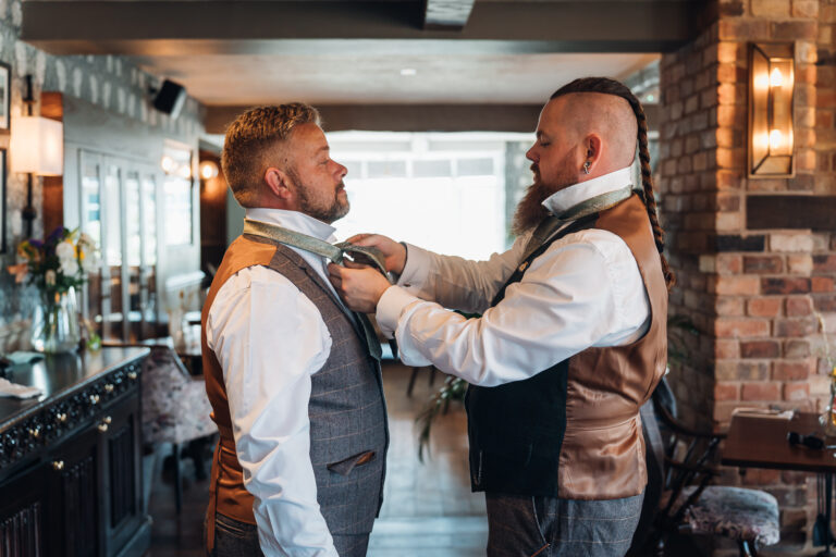 Groom ties best man's tie as they are getting ready at The Riverside Branston